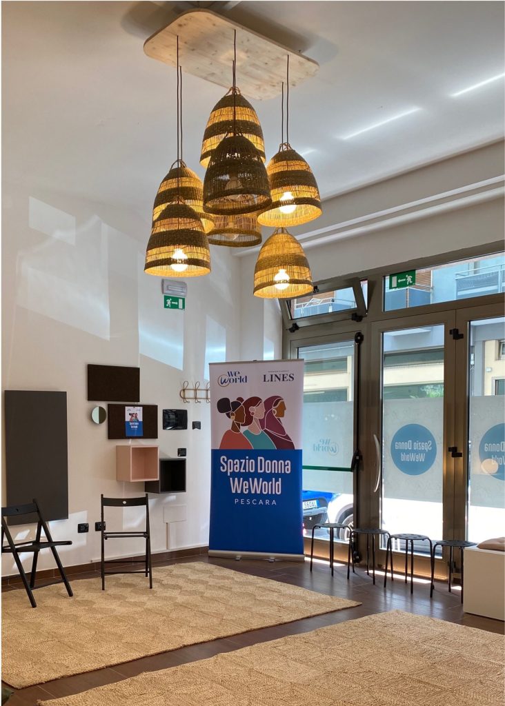 Interno di una sala con uno striscione Lines e WeWorld che indica Spazio Donna Pescara.