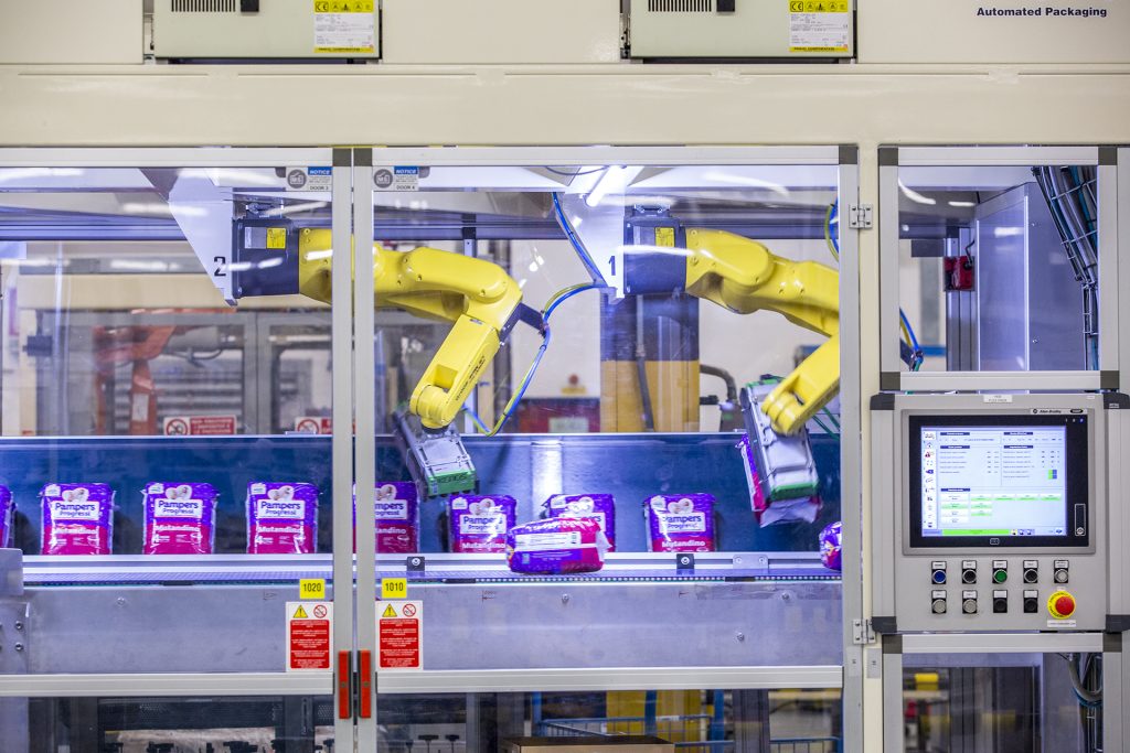Industrial robotic arm moves products inside an automated machine.