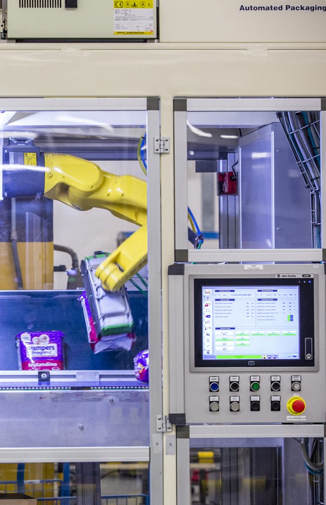 Braccio robotico industriale movimenta prodotti in una macchina automatizzata.